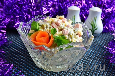 Выложить самый любимый, вкусный салат "Оливье", приготовленный с вареной колбасой, в салатник, украсить на свое усмотрение и подать к праздничному столу.