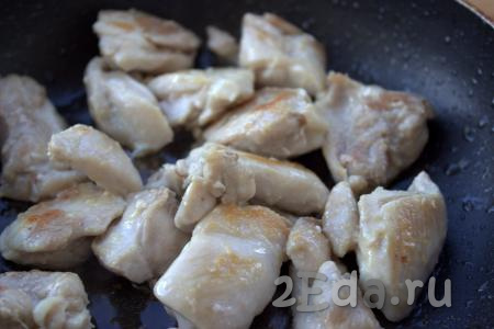 В сковороду влить растительное масло и разогреть, затем выложить кусочки курицы и жарить по 2-3 минуты с каждой стороны на среднем огне.