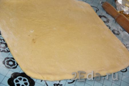 Хорошо обмять готовое тесто и на столе (или на силиконовом коврике), припылённом мукой, раскатать в пласт размером, приблизительно, 40 на 40 см. 