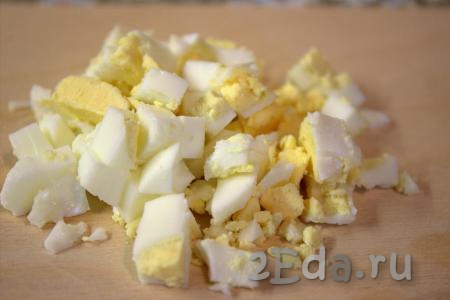 Куриные яйца отварить вкрутую (время варки составит 10 минут с момента закипания воды), затем охладить в холодной воде, очистить и нарезать средними кубиками.