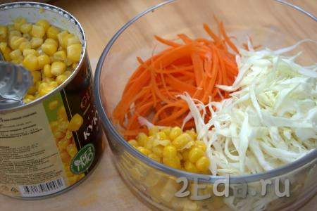 В миске соединить морковь и капусту. С консервированной кукурузы слить жидкость, добавить в миску с салатом из натёртой морковки и нарезанной капусты.
