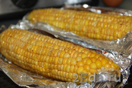 Выложить кукурузу, завёрнутую в фольгу, на противень и запекать 30 минут в духовке, разогретой до 200 градусов.