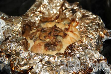 Выложить куриные мешочки с грибами, завёрнутые в фольгу, на противень и запекать в разогретой духовке минут 20 при температуре 200 градусов. Затем открыть верх фольги и поставить мешочки в духовку для подрумянивания ещё на 10-15 минут.