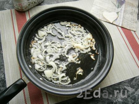 Выложить на сковороду нарезанный средними кусочками репчатый лук и обжарить его до лёгкой золотистости, иногда перемешивая.