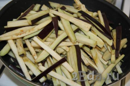В сковороду влить растительное масло и выложить баклажаны.