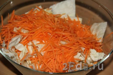 Очистить морковь, а затем натереть на крупной тёрке и выложить к капусте.