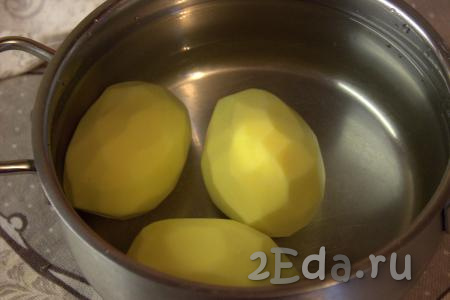 Картофель очистить, выложить в кастрюлю подходящего размера и залить холодной водой (воды в кастрюле должно быть ровно столько, чтобы полностью покрыть картошку). Поставить кастрюлю на огонь и дать воде закипеть, затем уменьшить огонь и отварить картофель в течение 3-4 минут. Снять кастрюлю с огня, слить воду и дать картошке немного остыть.