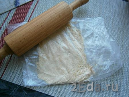Пару штук песочного печенья поместить в целлофановый пакет и измельчить его скалкой в мелкую крошку.