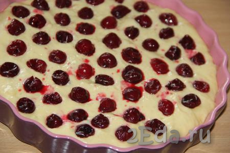 С предварительно размороженной вишни слить лишнюю жидкость. Выложить ягоды на тесто. Вместо замороженных ягод в этом рецепте можно использовать и свежую вишню без косточек.