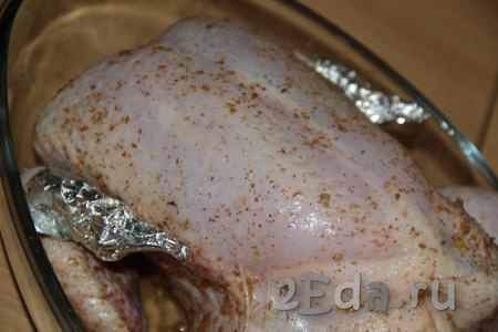 Переложить курицу, фаршированную картошкой, в жаропрочную форму. Кончики крылышек можно прикрыть фольгой, чтобы они не подгорели во время запекания в духовке.