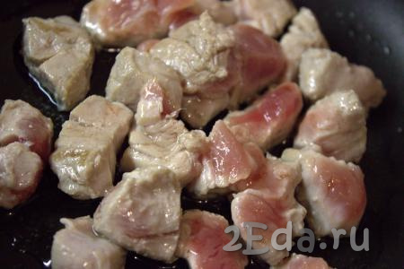 В сковороде разогреть растительное масло, выложить кусочки свинины, обжаривать мясо на сильном огне 2-3 минуты, периодически переворачивая.