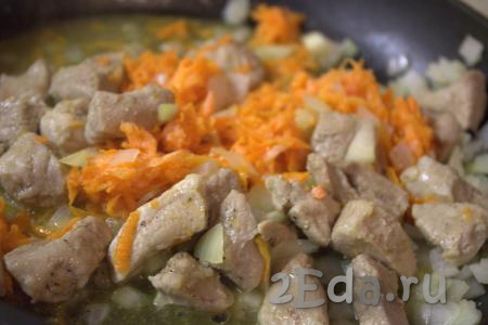 Затем в сковороду к луку и мясу добавить очищенную и натёртую на крупной тёрке морковь. Обжаривать овощи с мясом, не забывая помешивать, ещё 5-7 минут.