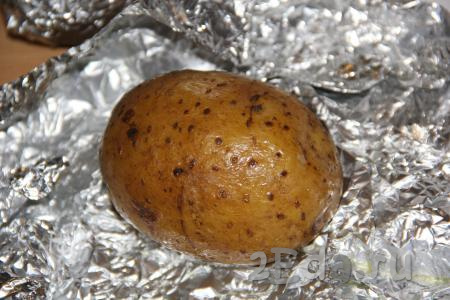 Достать из духовки запечённый картофель, развернуть фольгу. На поверхности каждой горячей картошины сделать крестообразный разрез.