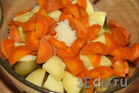 Морковь нарезать полукружочками. Чеснок очистить и пропустить через пресс. Соединить нарезанные кальмары, картофель, огурцы, морковь, лук, добавить чеснок.