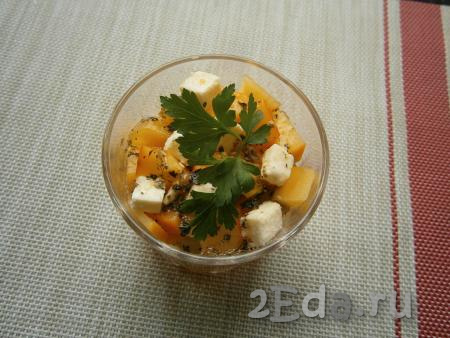 Полить салат с хурмой и сыром приготовленной мандариновой заправкой, украсить зеленью.