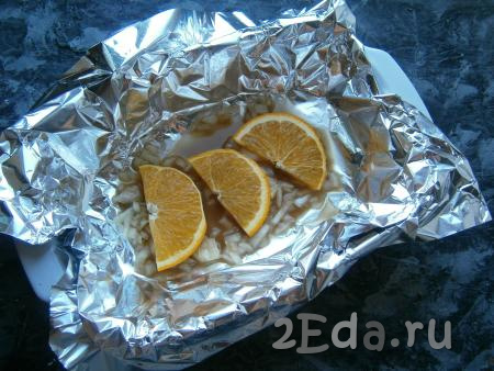 Форму застелить фольгой, вылить половину медово-соевого маринада. Оставшуюся половину апельсина нарезать тонкими дольками, 3-4 дольки выложить на дно формы для запекания.