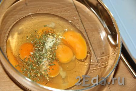 В отдельной миске соединить сырые яйца, добавить немного соли и специй.