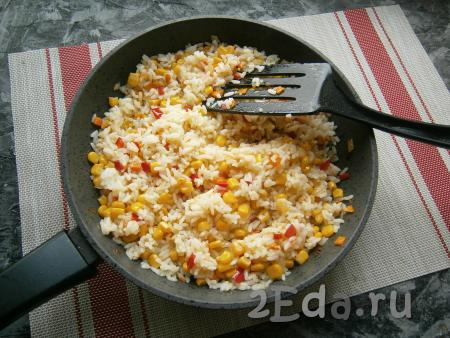 Добавить маленький измельчённый зубчик чеснока, затем аккуратно перемешать рис с кукурузой и болгарским перцем и прогреть на небольшом огне минут 5, периодически помешивая.