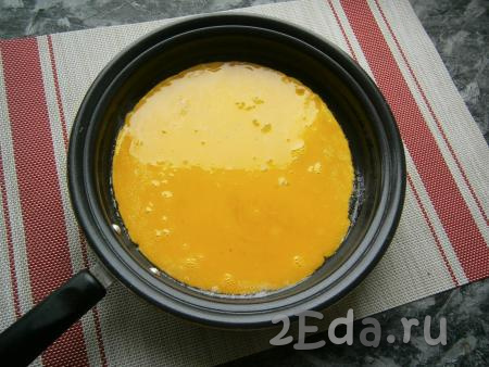 Смазать маслом и бока сковороды. Вылить в неё желтковую смесь, равномерно распределяя по дну сковороды.