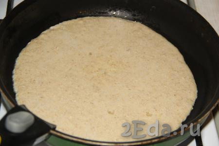 В сковороду диаметром 26 см влить 1 чайную ложку растительного масла, разогреть. Вылить сразу всё тесто и распределить равномерно по всей поверхности сковороды, жарить овсяноблин на среднем огне.