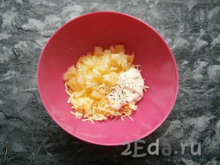 К сыру добавить нарезанные ананасы, пропущенный через пресс чеснок, майонез, немного соли и молотого чёрного перца.