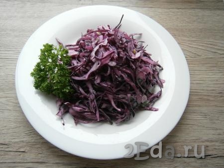 Выложить салат горкой в тарелку и украсить зеленью.