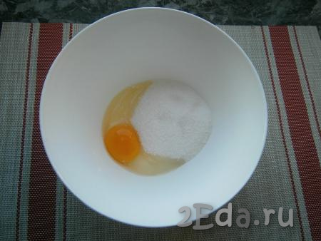 В миску разбить яйцо, всыпать щепотку соли и 120 грамм сахара.