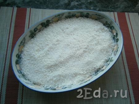 Засыпать тесто полностью смесью кокосовой стружки и сахара, аккуратно разровнять.