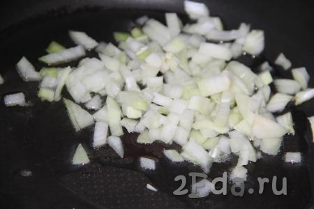 В сковороду влить немного растительного масла, разогреть и выложить мелко нарезанный очищенный лук.