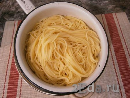 Поместить спагетти в кипящую подсоленную воду и отварить до готовности (в соответствии с инструкцией на упаковке), затем откинуть их на дуршлаг.