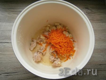 Лук, морковь, чеснок и картофель очистить. Растительное масло налить в чашу мультиварки, выложить кусочки куриного мяса, выставить режим "Выпечка" на 20 минут. Обжаривать курицу, помешивая, в течение 10 минут, после чего добавить натертую на крупной терке морковь и нарезанный репчатый лук.