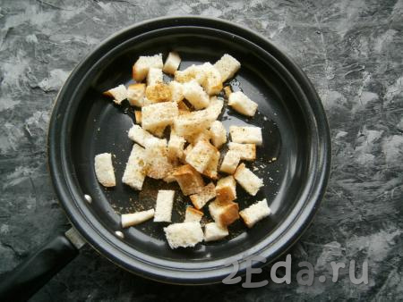 Батон нарезать небольшими кубиками (брусочками), сбрызнуть оливковым маслом, перемешать, посыпать итальянскими травами и выложить на сковороду.