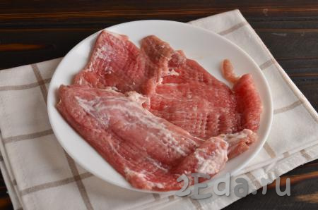 Далее кусочки мяса нужно накрыть пищевой пленкой и отбить с одной стороны кулинарным молотком.