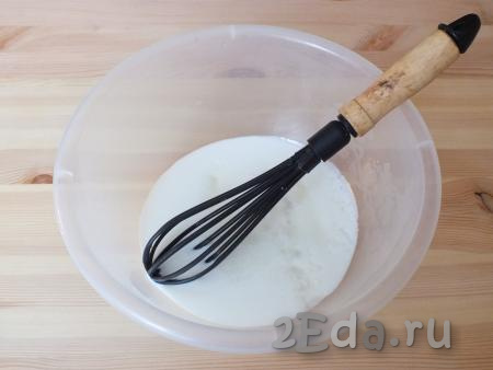 Для замешивания теста налейте в миску кефир комнатной температуры. Добавьте к нему сахар, соль и размешайте венчиком.