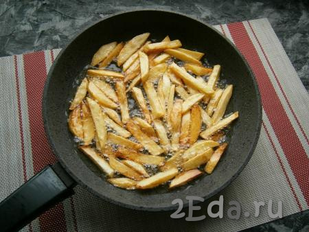 Жарить картофель фри, не перемешивая, на среднем огне, до румяности нижней стороны брусочков. Затем можно картошку перемешать и дать зарумяниться ей с других сторон.
