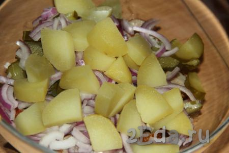 Картофель сварить в мундире, остудить, очистить и крупно нарезать. Добавить картошку и лук в салатник.