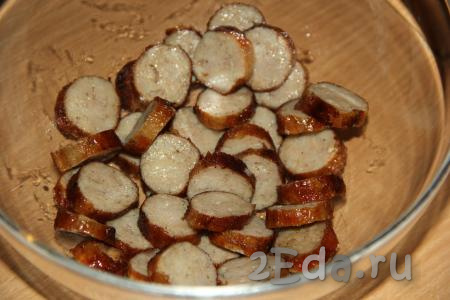 Переложить нарезанные баварские колбаски в салатник.