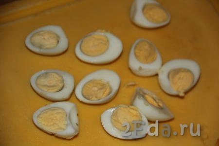 Перепелиные яйца сварить в течение 7 минут, остудить. Очистить яйца и разрезать на две части.
