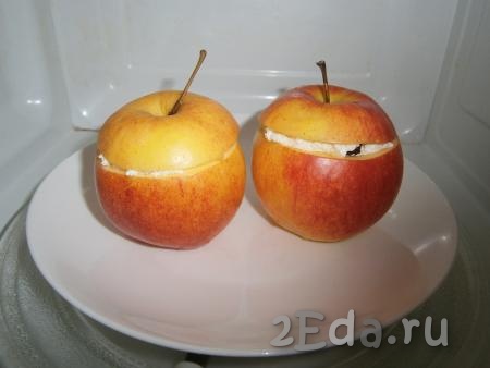 Отправить яблоки с творогом в микроволновку на 5 минут (накрыть специальной крышкой с отверстием для выхода пара) при мощности 750 Ватт. 