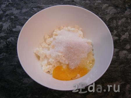 В творог всыпать сахар, щепотку соли, сырое яйцо и ванильный сахар.