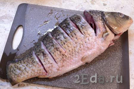 Карпа очистить от чешуи и внутренностей, удалить жабры. Рыбу хорошо вымыть и сделать 6-7 глубоких разрезов по спинке (это облегчит деление карпа на порции после приготовления).