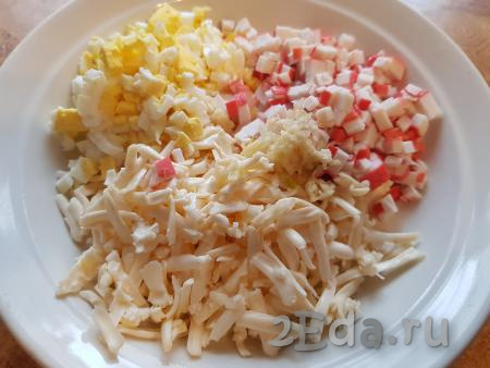 Соединить сыр, нарезанные крабовые палочки и яйца, добавить немного соли и пропущенный через пресс чеснок.