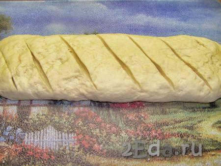 Делим тесто на две части. Из каждой части теста формируем хлеб в виде батона. Делаем острым ножом диагональные надрезы глубиной около 1 см.