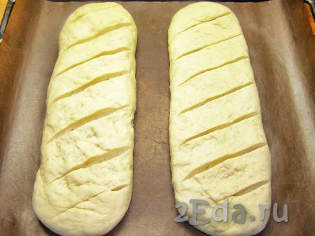 Противень застилаем пекарской бумагой (или силиконовым ковриком для выпечки) и выкладываем на него заготовки хлеба на расстоянии 5-7 см друг от друга. Оставляем для расстойки минут на 20, прикрыв тесто полотенцем. В это время можно прогреть духовку до 190-200 градусов.