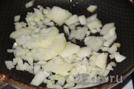 Влить растительное масло в сковороду, добавить предварительно очищенный и мелко нарезанный репчатый лук.