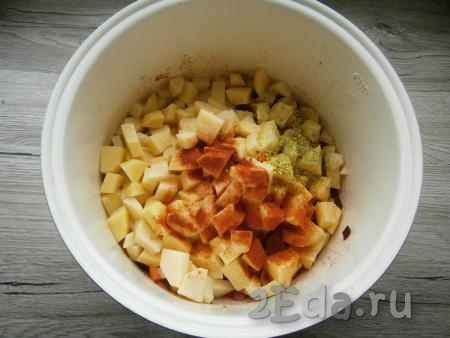 Затем добавить нарезанный кубиками картофель, всыпать приправу для овощей, соль по вкусу, а также паприку. Влить горячую воду, перемешать, выставить режим "Тушение" на 1 час, крышку мультиварки закрыть.