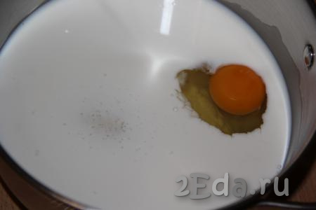 В толстостенную кастрюлю влить молоко и добавить яйцо.