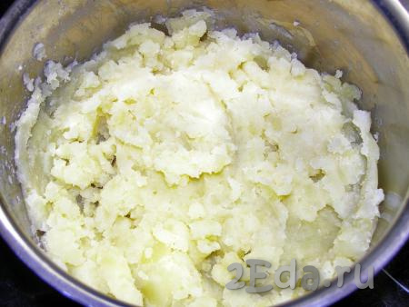 С отварного картофеля сливаем воду и разминаем, чтобы получилось пюре. Оставляем немного остыть.