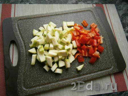 На кубики чуть большего размера нарезать болгарский перец и кабачок (если кабачок молодой, его можно готовить вместе с кожурой).