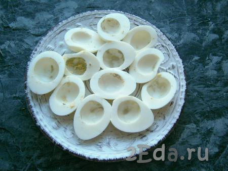 Разрезать яйца на 2 половинки, желтки поместить в отдельную мисочку, белки выложить на тарелку.